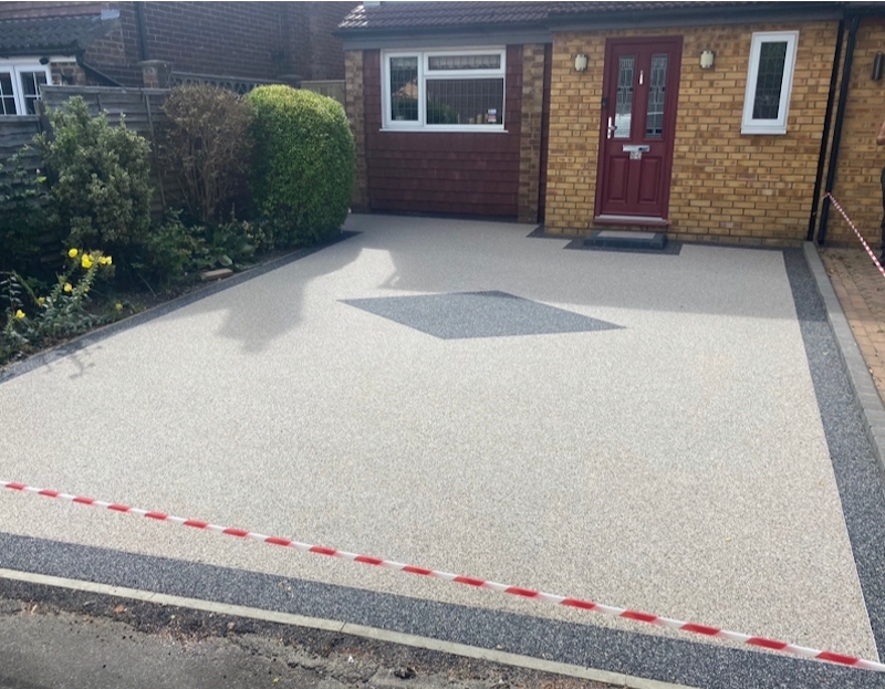 Finished light resin driveway with a contrasting central feature