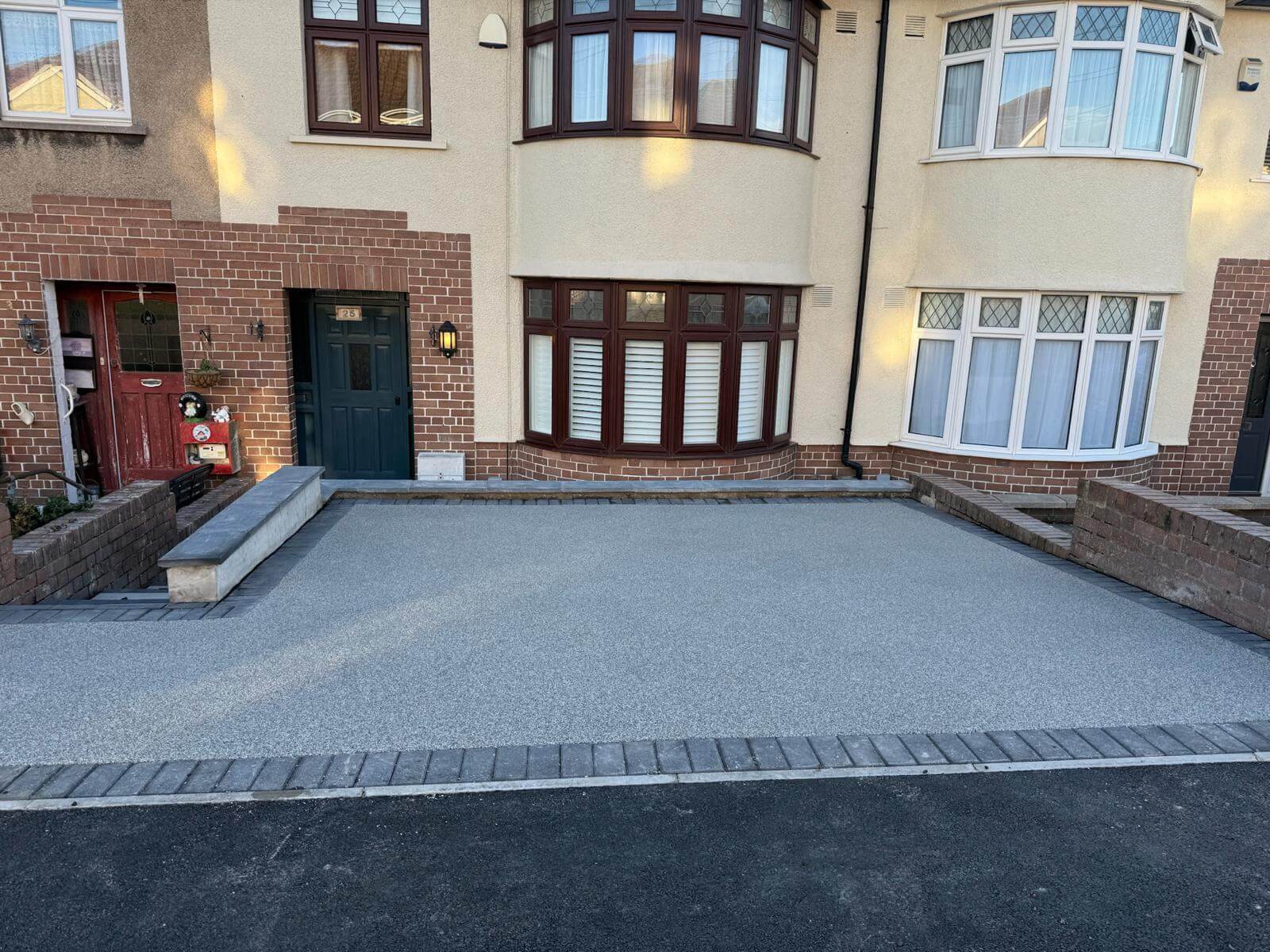 Dark grey resin driveway with a decorative block threshold